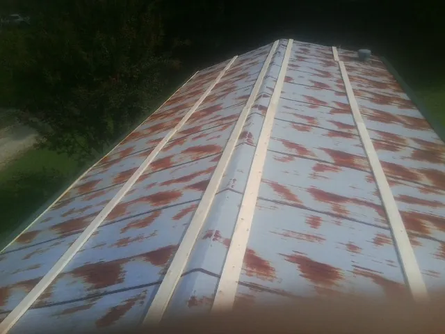 Rusted metal roof panels with new wood purlins before replacement — Storm Damage Roof Repair in Rutland by Roofing Brothers